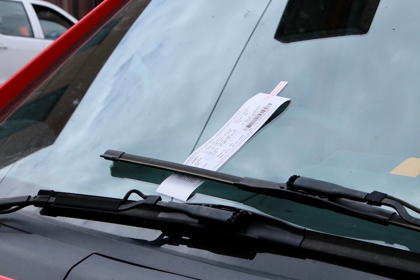 A parking ticket on a car windscreen.