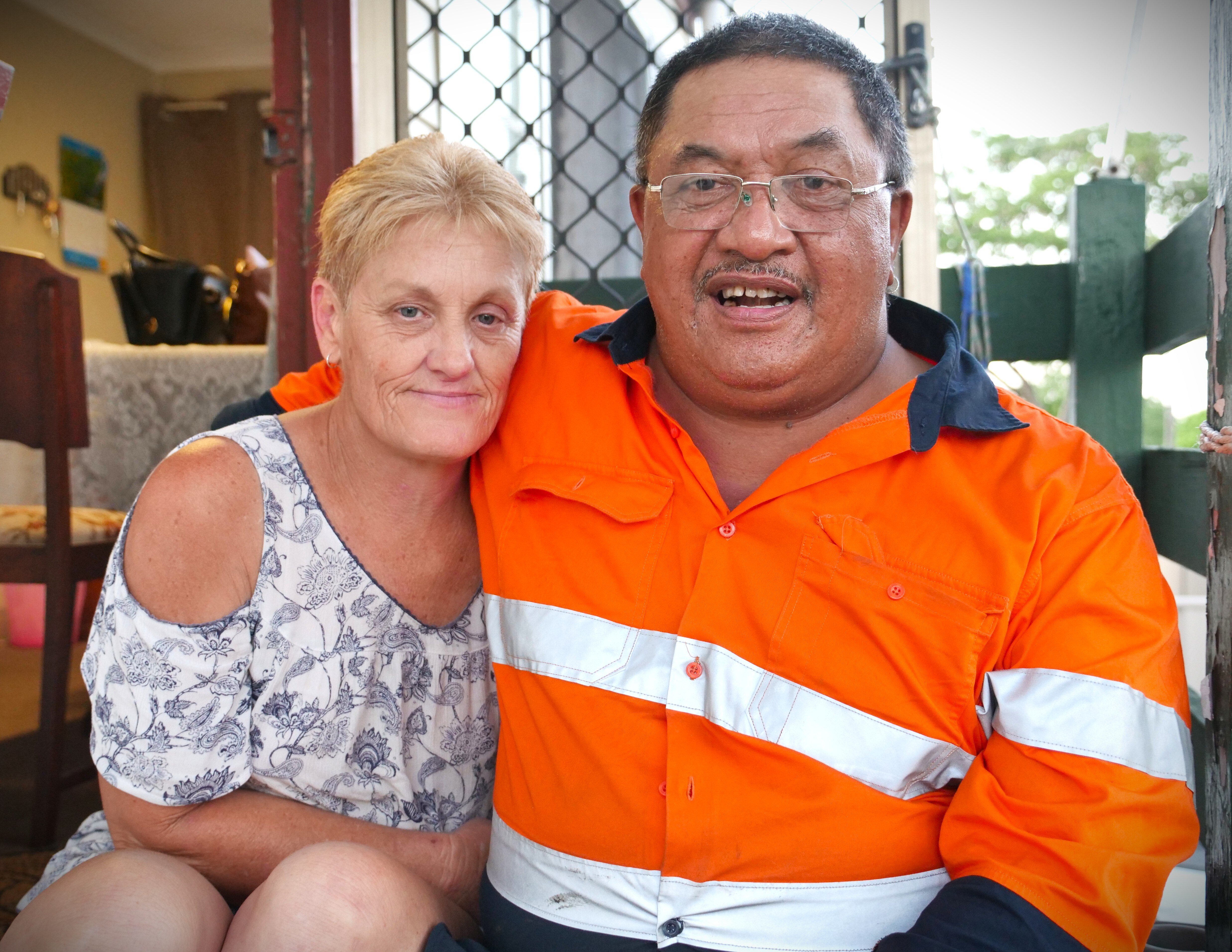 Johnnie Tumai, con gafas, sentado en una escalera junto a una sonriente Vickie Saunderson