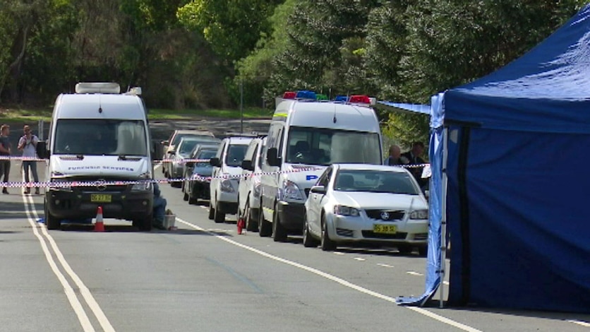 Police inspect an abandoned car after a man's body was found in the boot