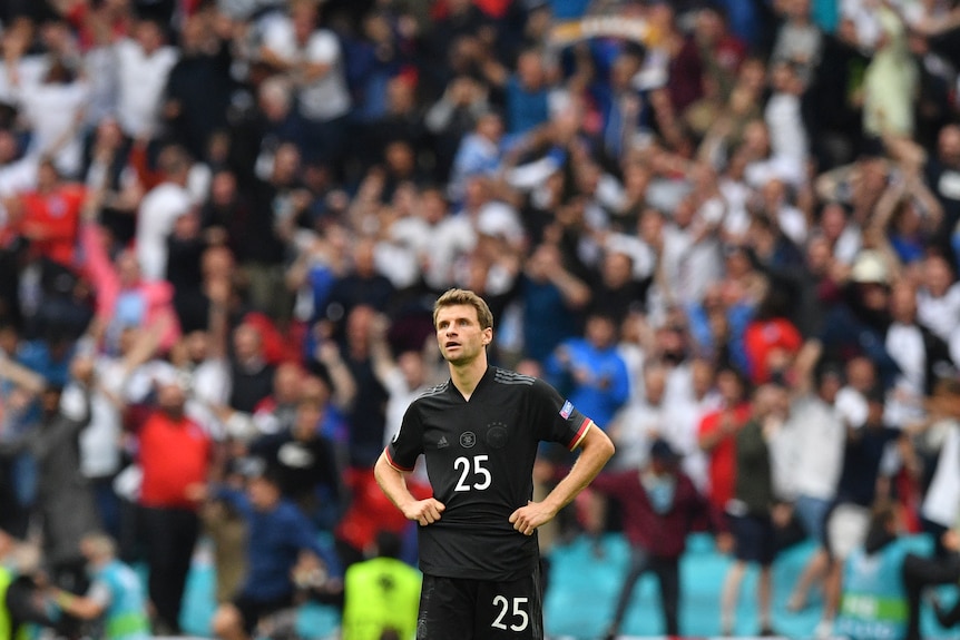 Thomas Mueller stands with his hands on his hips.