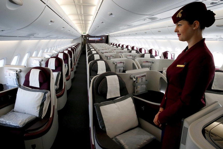 A Qatar air hostess greets passengers on a new A380 aircraft