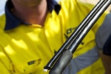 Hands hold an optic fibre wire during installation of Tasmania's NBN