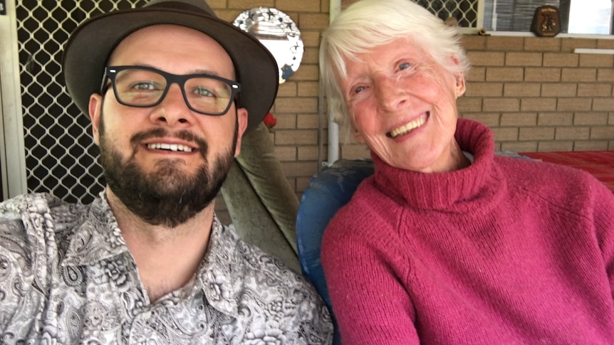 A close-up photo of Jordan Shields and Joy Denys sitting outside a house.