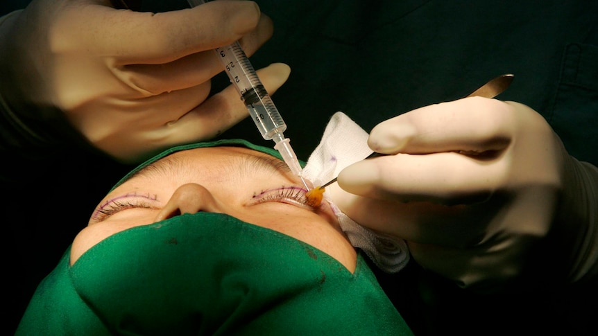 A plastic surgeon operates on a patient.