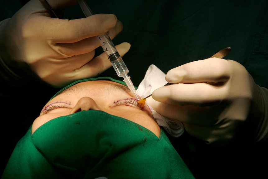 Close up of someone having a cosmetic injection near their left eye