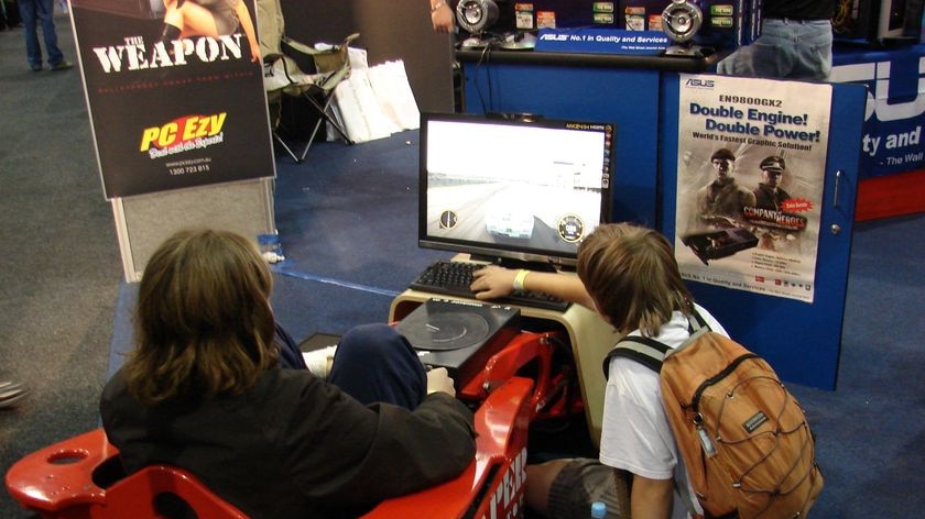 Person playing a video game in red racing car at the biggest gaming convention in Australia.