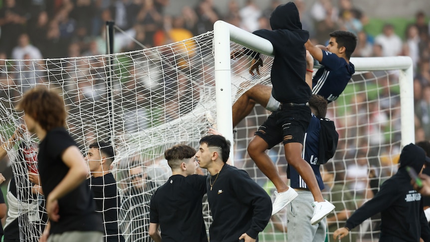 Fans storm the pitch in protest during the round eight A-League Men's match between Melbourne City and Melbourne Victory.