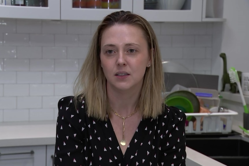 A woman sits in a home kitchen