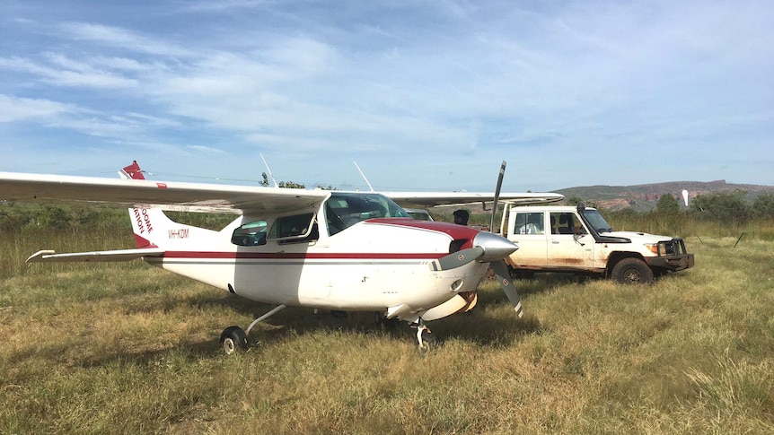 Light plane parked next to a ute in remote country