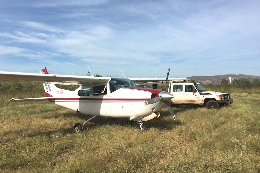 Light plane parked next to a ute in remote country