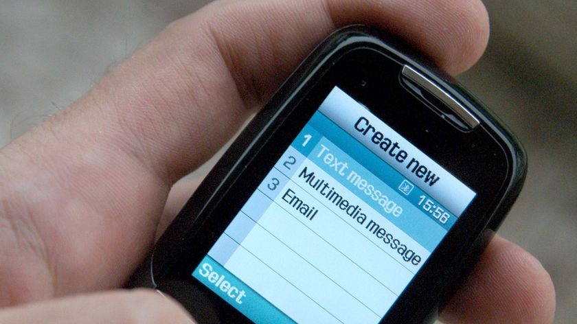 Close up of a hand holding a mobile phone and about to type/send a text message