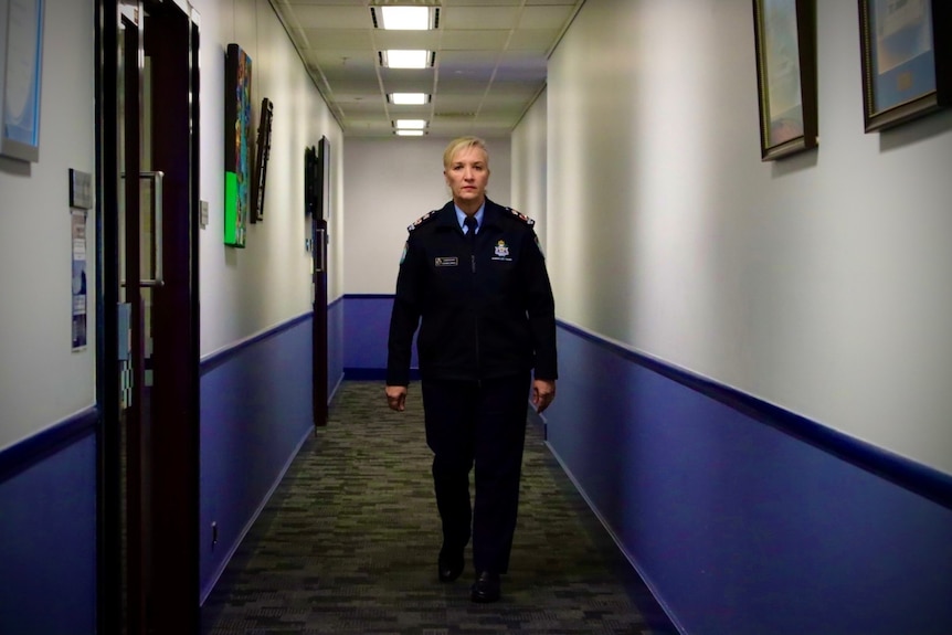 Katarina Carroll walking down the hall under neon lights.  