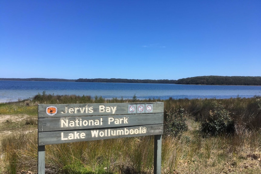 A sign saying Jervis Bay National Park at a coastal area