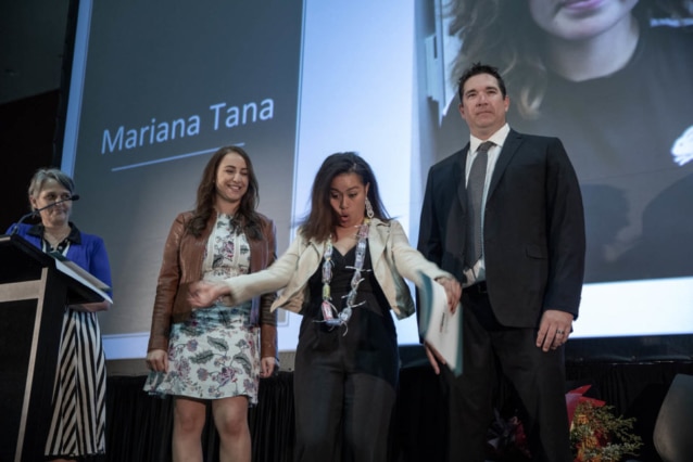 girl celebrating on stage surrounded by teachers