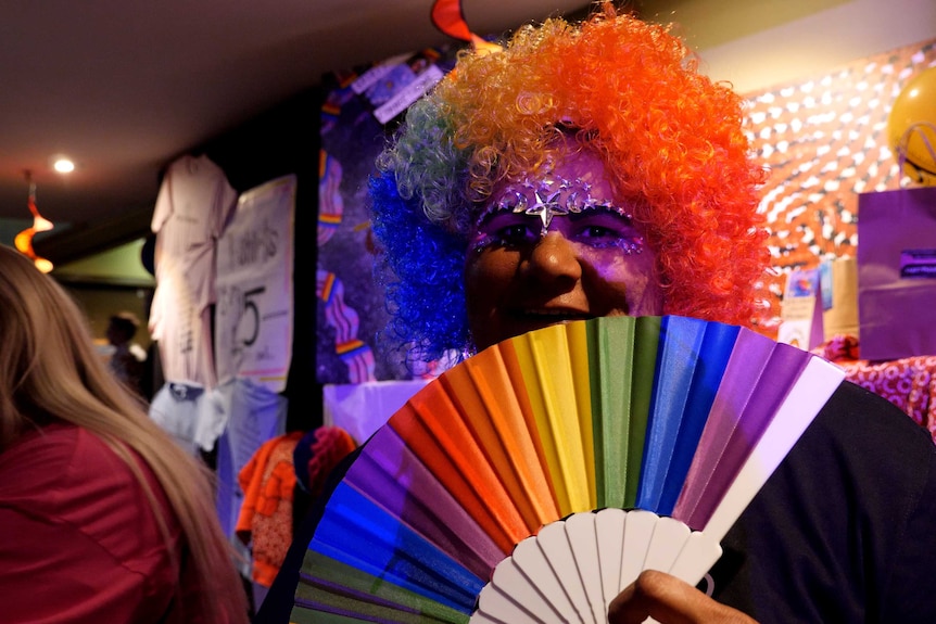 A person in a rainbow wig