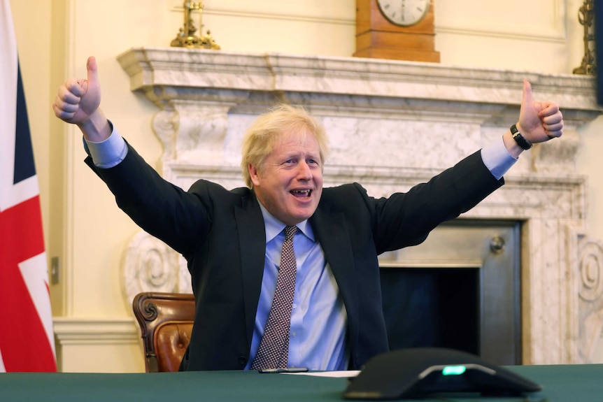 Boris Johnson smiles with two thumbs in the air.
