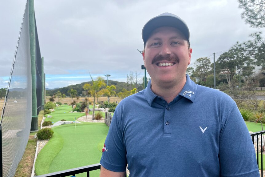Profile shot of Tom Major standing in front of the Coffs Coast mini golf course. 