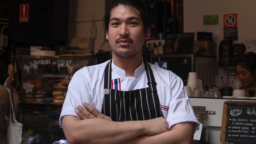 Close up shot of a man in apron with arms crossed