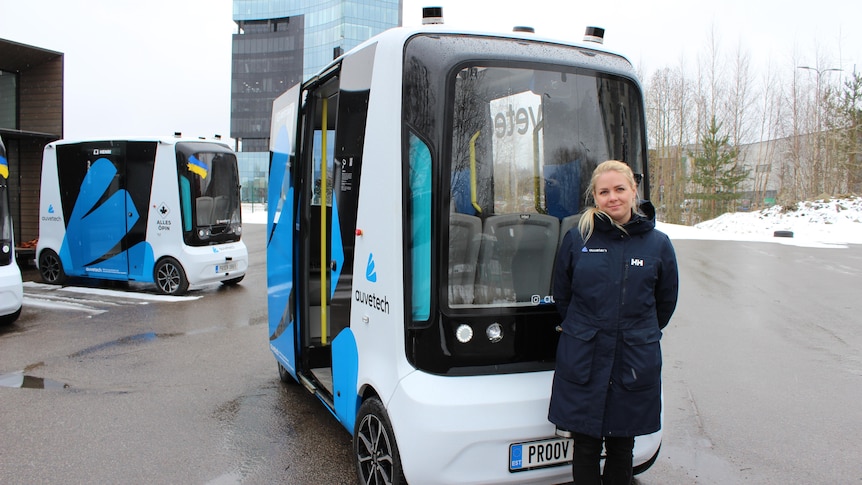 Mari-Ly Klaats stands in front of an autonomous minibus