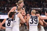 Carlton players huddle together to celebrate a Patrick Cripps goal
