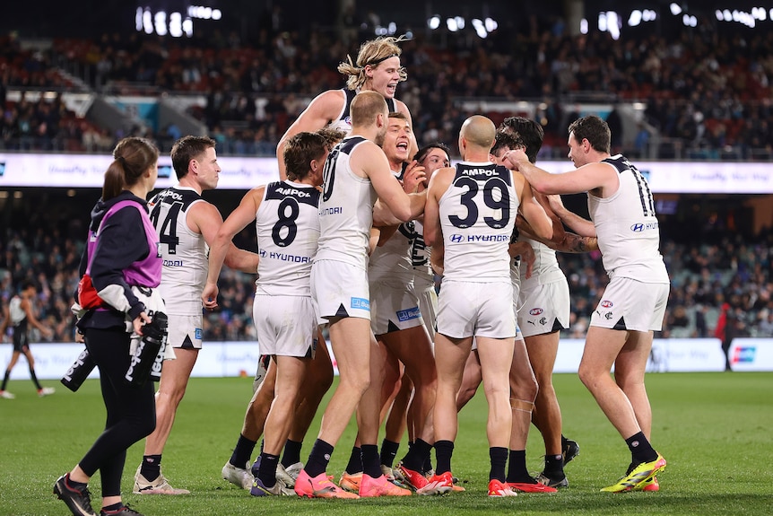 Carlton players huddle together to celebrate a Patrick Cripps goal