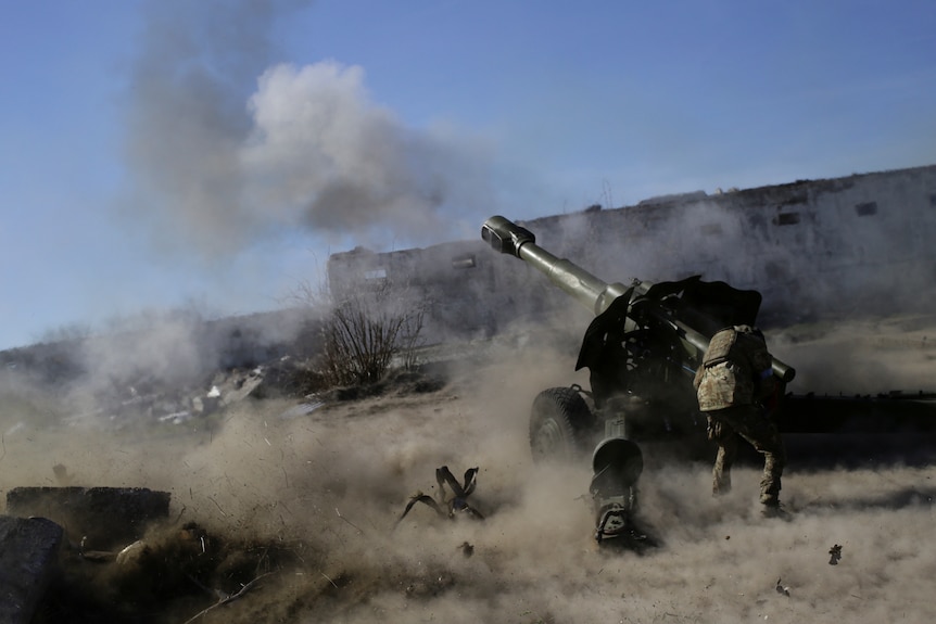 A Ukrainian soldier fires a howitzer.