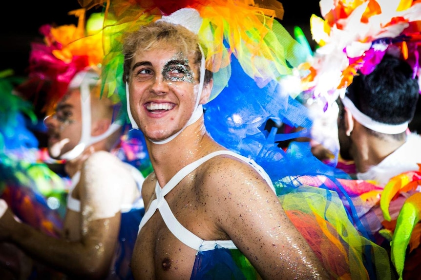 Man with coloured ribbons in hair smiling