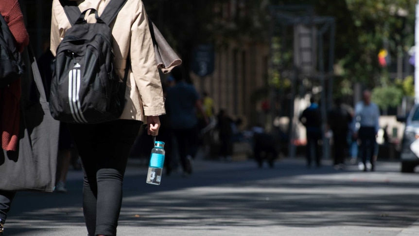 A shot of the back of a university student walking on the streets of Melbourne.