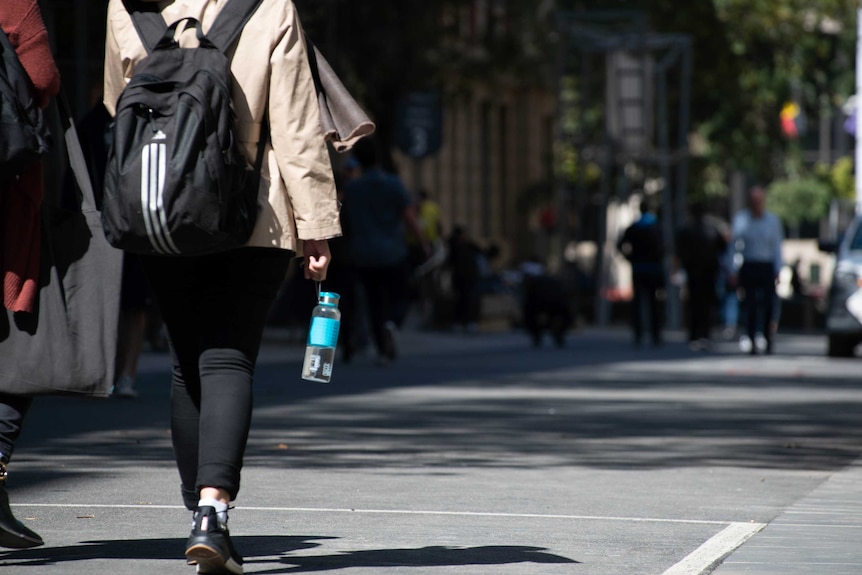 A shot of the back of a university student walking on the streets of Melbourne.