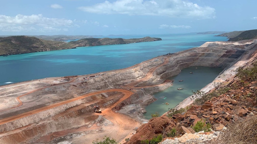 Aerial of iron ore mine on island with seawall