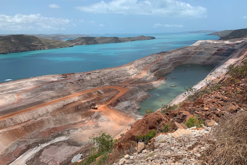 Aerial of iron ore mine on island with seawall