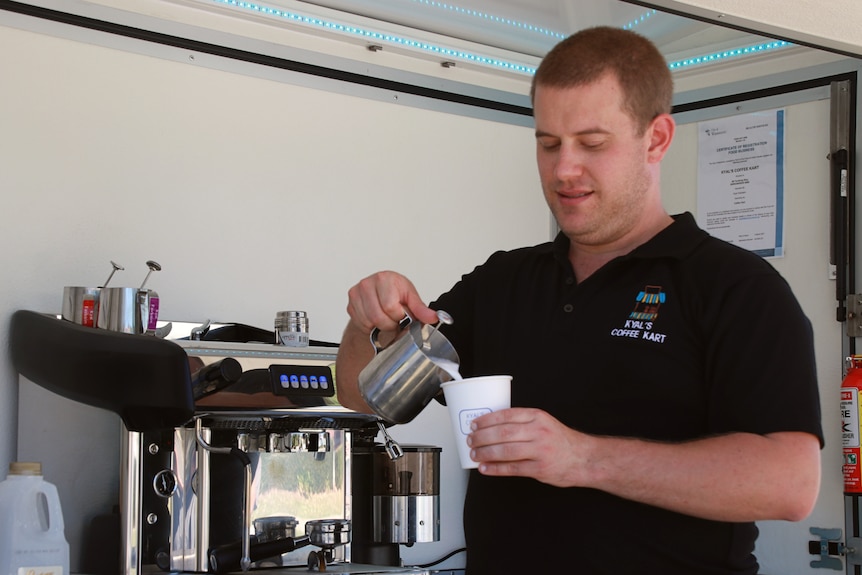 A short haired man standing in front of a coffee machine pours milk into a jug Ausnew Home Care, NDIS registered provider, My Aged Care