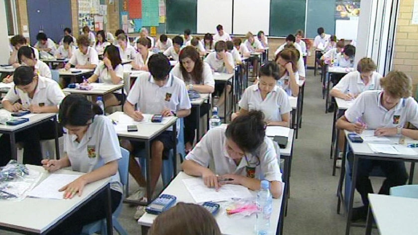 Rows of students study for exams.