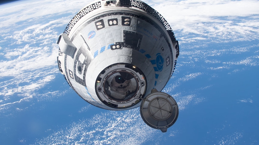 Boeing's Starliner crew ship opens it's hatch as it approaches the ISS. Earth's weather over the ocean in the background.