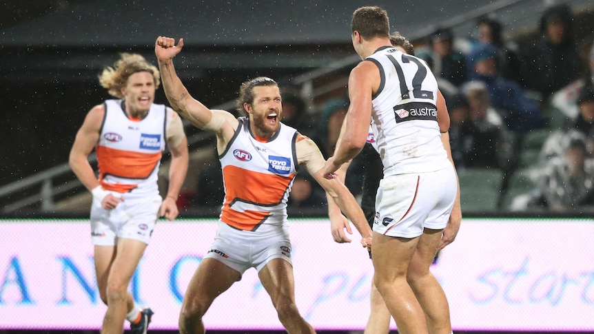 GWS' Sam Reid (C) reacts to a goal from Jonathon Patton (R) against Port Adelaide at Adelaide Oval.