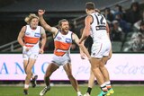GWS' Sam Reid (C) reacts to a goal from Jonathon Patton (R) against Port Adelaide at Adelaide Oval.