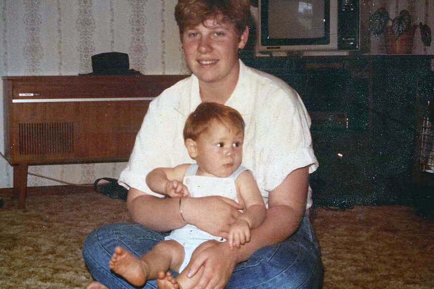 A 1980s photograph of a young woman holding a baby