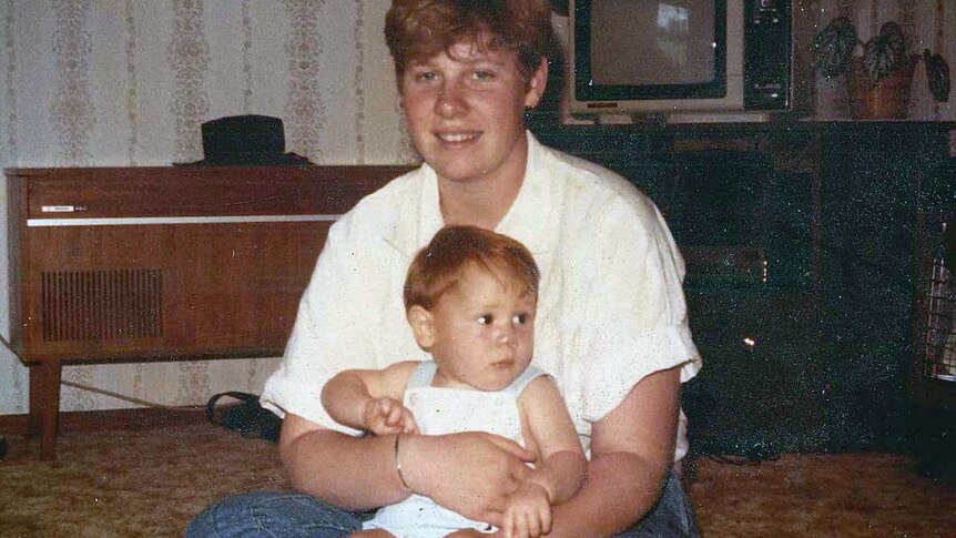 A 1980s photograph of a young woman holding a baby