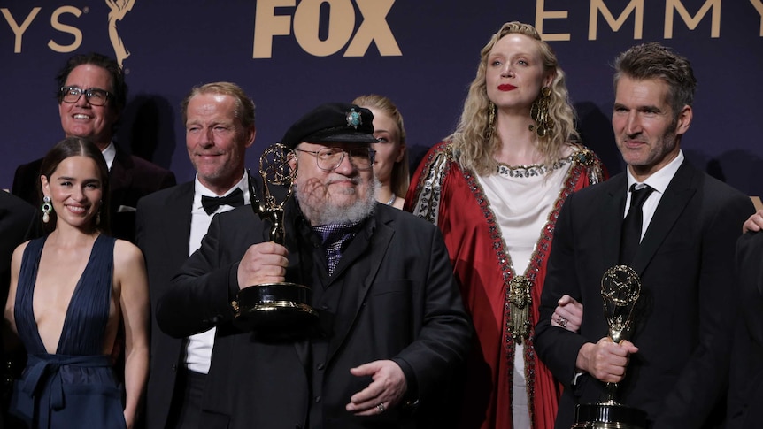 George R.R. Martin (C) and the cast and crew of Game of Thrones poses backstage with their award for Outstanding Drama Series.