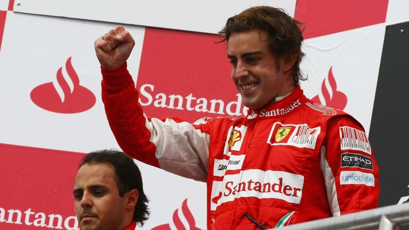 Dirty win? Alonso (r) stands on top of the podium after a free ride from team-mate Massa.