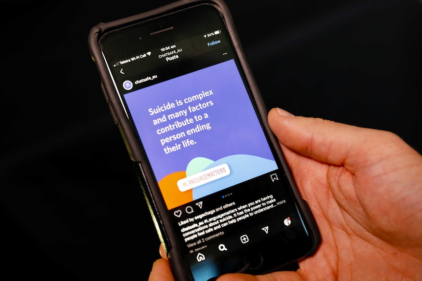 Someone holding an iphone looking at an instagram post about suicide saying it is a complex issue.