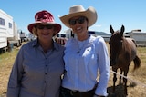 Raelene and Danielle Smith stand in front of their horse.