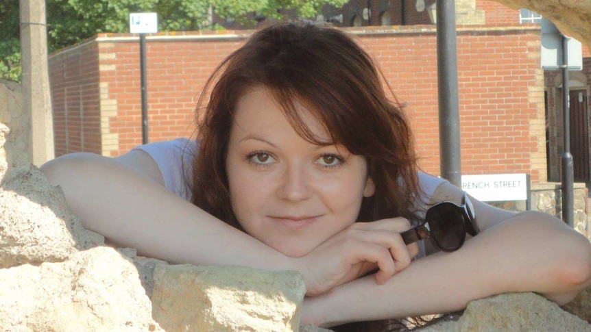 Yulia Skripal smiles while looking though hole in rock formation