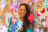 Maryann Talia Pau stands amongst hanging paper stars.