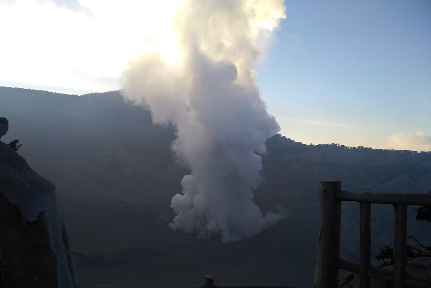 A volcano erupting a cloud of ash