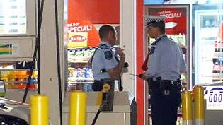 Police investigate a service station robbery