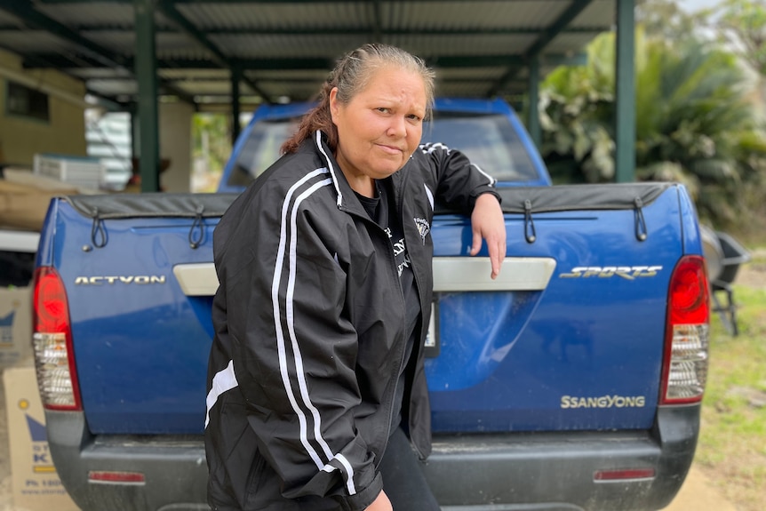 Kellie stands in front of a blue ute