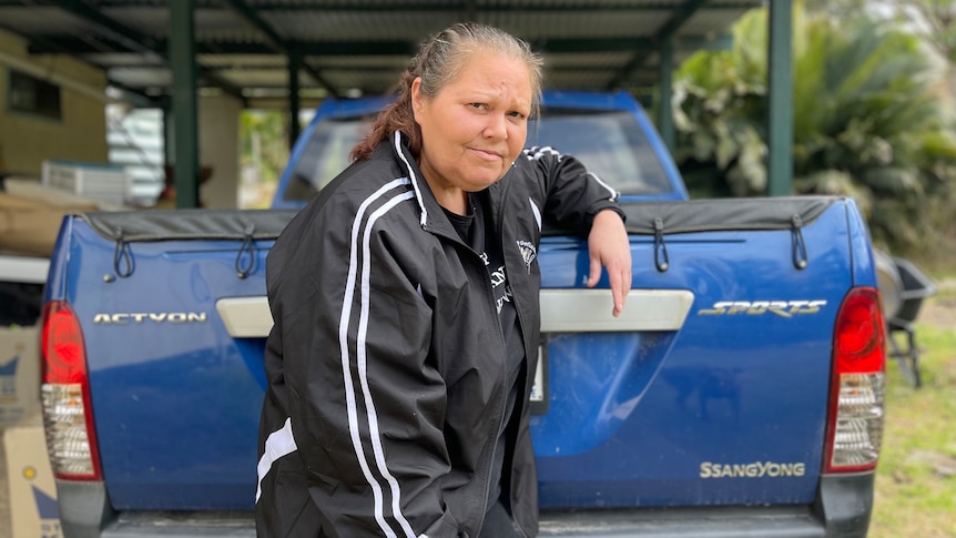 Kellie stands in front of a blue ute