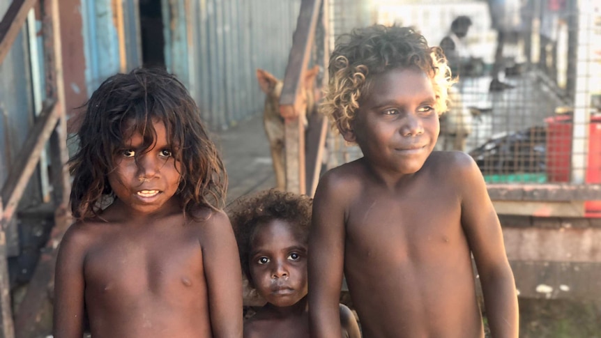 Three children look at the camera