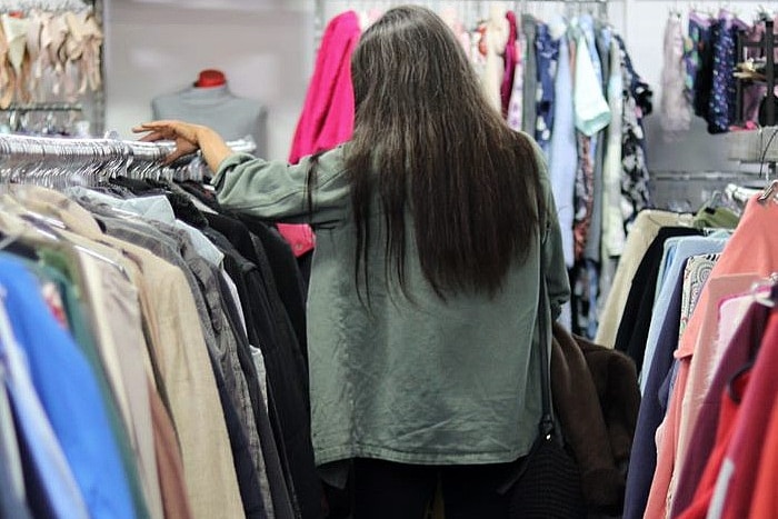 A woman in a green jacket at an opp shop